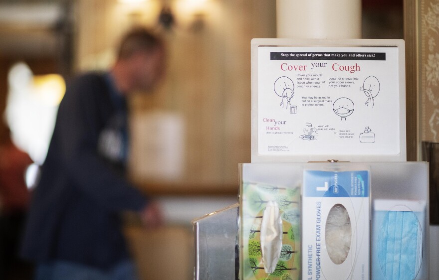 In this March 6, 2020, photo, tissues, gloves, and masks greet visitors at the South Shore Rehabilitation and Skilled Care Center, in Rockland, Mass. 