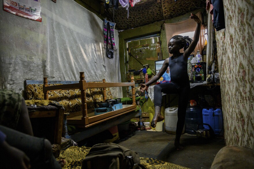 Valentine Ayuma, a 10-year-old ballet dancer, follows a Facebook Live stream at home. The dance session was organized by Mike Wamaya, founder of the nonprofit Project Elimu. Due to lockdowns when the pandemic began, students in Kenya were trained via streamed recordings. <em>May 22. Kibera, Kenya.</em>