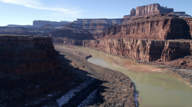 A muddy river flows between cliffs