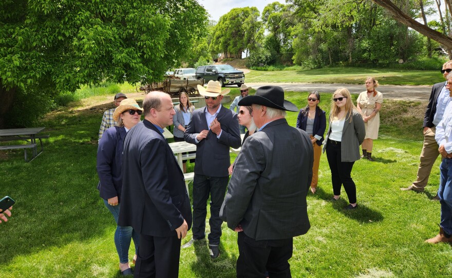 Governor Jared Polis (left) visits with State Senator Perry Will (right) during a bill signing in Paonia, Colorado