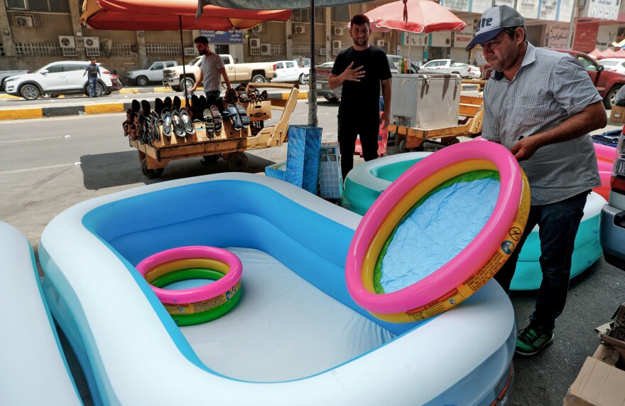 A shopkeeper sells children's inflatable tubs on a street in Baghdad on June 30, 2021 during a severe heat wave.