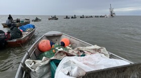 Skiffs line up to offload their salmon catches to a tender vessel floating in the waters of Kuskokwim Bay near Quinhagak during the first commercial salmon fishing opener of the season on July 7, 2026.
