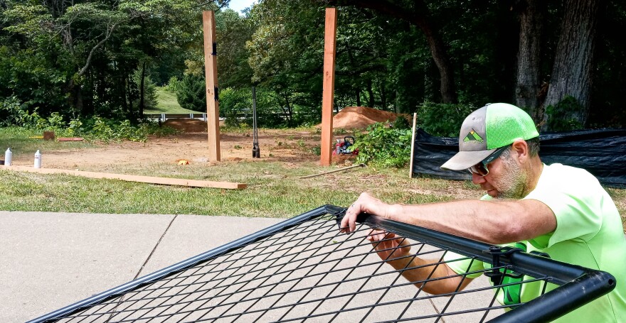 Brad Scales, Trailhead Southwest Indiana executive director, assembles the Campus Flow trail sign at the University of Southern Indiana Thursday, June 22. The sign was the final step to finish the trail, which was delayed several months for a variety of reasons.