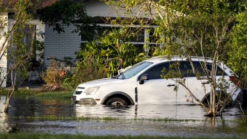 A car sits in high water in front of a home in the aftermath of Hurricane Milton, Thursday, Oct. 10, 2024, in Tampa.