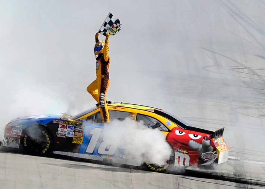 FILE - Kyle Busch celebrates his win in the NASCAR Sprint Cup Series' Autism Speaks 400 auto race, Sunday, May 16, 2010, in Dover, Del. (AP Photo/Nick Wass, File)