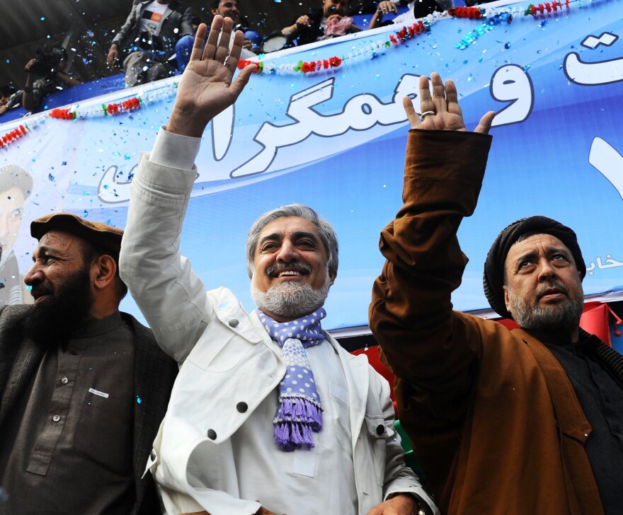Afghan presidential candidate Abdullah Abdullah (center) and his vice presidential candidates Mohammed Mohaqiq (right) and Mohammad Khan (left) wave to their supporters at a rally in the northwestern city of Herat on Tuesday.