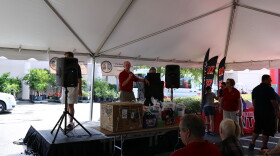 SC Department of Insurance Director Ray Farmer stand on stage speaking into a microphone, welcoming the crowd.