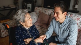 Young man sitting next to an aged woman