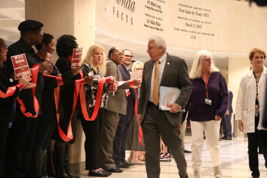 Protesters opposing HB1, a bill they say is "union busting," formed lines leading to the House chambers March 4, 2020. Democratic Rep. Richard Stark, center, is seen here walking past the demonstration before a Houses session that saw the bill pass.