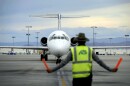 In this Thursday, May 9, 2013, photo, an airline ground worker guides an incoming Allegiant Air jetliner at McCarran International Airport, in Las Vegas. While other U.S. airlines have struggled with the ups and downs of the economy and oil prices, tiny Allegiant Air has been profitable for 10 straight years. (AP Photo/David Becker)