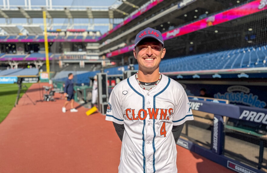 Baseball player dressed in Indianapolis Clowns uniform smiles for the camera on the field at Progressive Field in Cleveland.