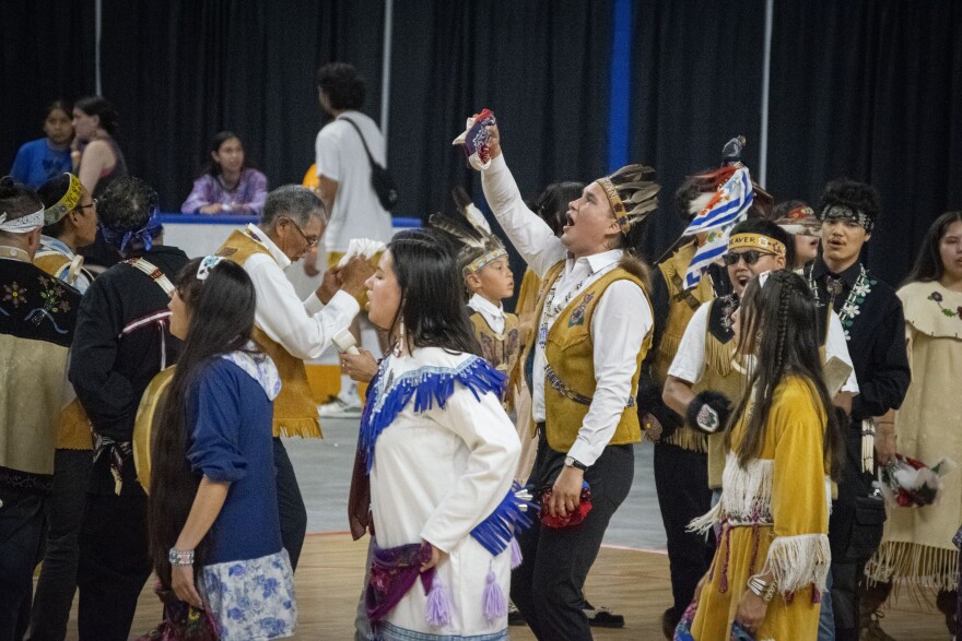 World Eskimo-Indian Olympics singers and dancers cluster on one end of the arena of the Carlson Center on July 19, 2025.