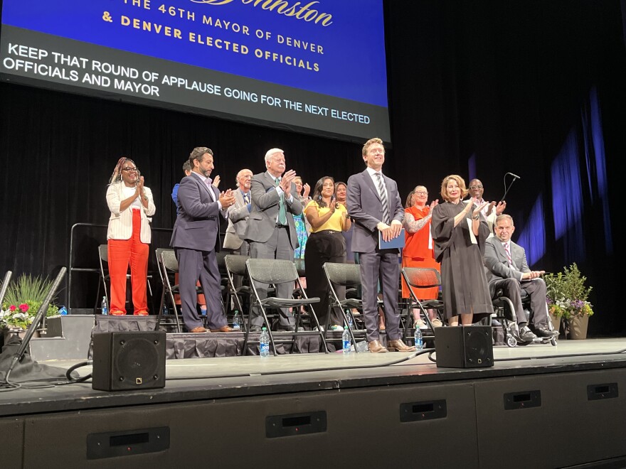 Incoming mayor Mike Johnston (center) stands in front of the other elected officials who were sworn-in during the ceremony after taking his oath of office on Monday, July 17, 2023. Apart from Johnston, the city auditor, city clerk and 13 city councilmembers took their oaths of office.