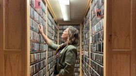 A woman looks through CDs on shelves in a music library.