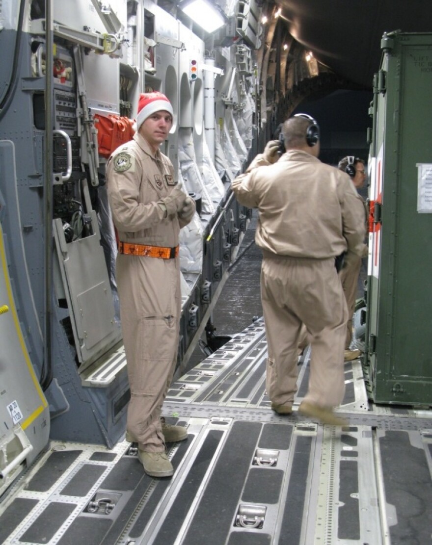 Air Force Capt. Blake Putnam, left, helps convert the massive hold of the C-17 plane from carrying cargo into a flying hospital.