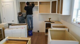 Daryl Shirk and Delmar Hoover, left, install a set of kitchen cabinets inside a new home on Tuesday, Jan. 16, 2024, in Mayfield, Ky.