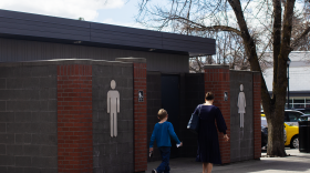 A woman and child walk past a public restroom in downtown Moscow, Idaho, on Friday, April 3.