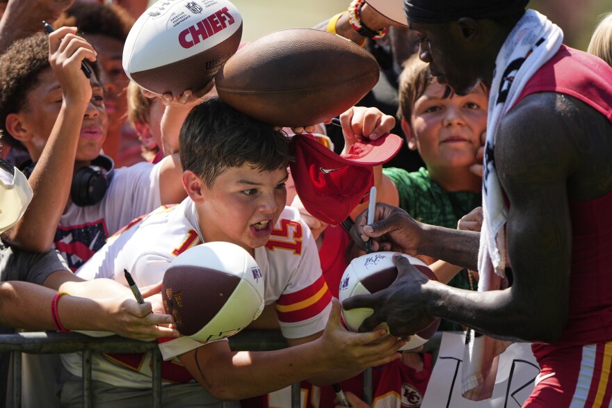 Kansas City Chiefs wide receiver Xavier Worthy signs autographs during Back Together Weekend at the team's NFL football training camp, Sunday, July 27, 2025, in St. Joseph, Mo.