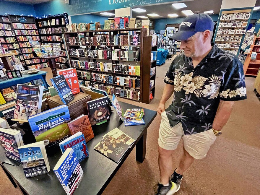 Otto Bookstore manager John Shableski looks at a display of baseball-related books at the shop Tuesday afternoon ahead of the Little League World Series Grand Slam Parade in downtown Williamsport. 'We started seeing little league families coming in a few days ago, which is really quite nice,' Shableski said.