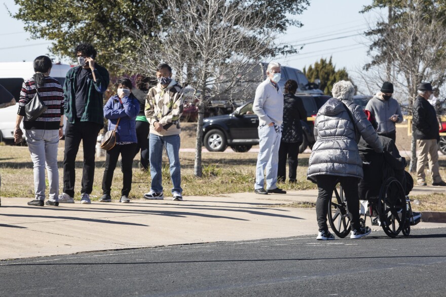 People wait in line for a COVID-19 vaccine from Austin Public Health in January. 