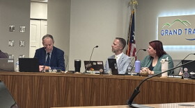Traverse City city attorney Dan Kelly answers questions about the prowling ordinance in a city commission meeting while seated next to City Manager Benjamin Marentette and Mayor Amy Shamroe. (IPR News / Maxwell Howard)