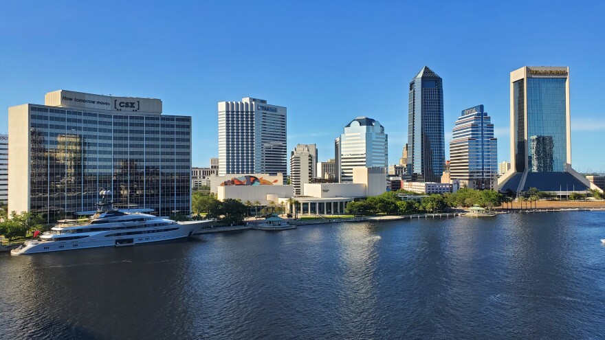 Jacksonville Skyline, featuring a large ship on the bank, and some tall buildings.