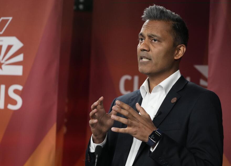 Man in suit speaks at podium