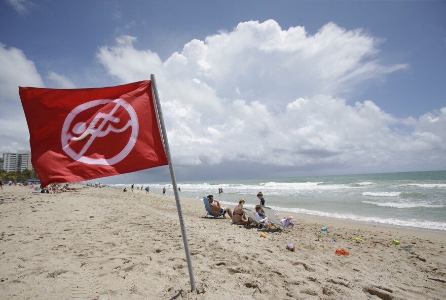 A no swimming flag flies on the beach in an area where there is a known rip current, Tuesday, May 13, 2014 in Fort Lauderdale, Fla.