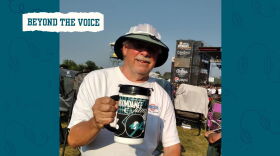 Man holds a mug at a music festival