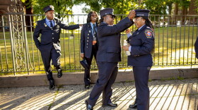 Kristie McNeill-Free (left) adjusts Sheena Spence’s hat before a march in Hartford of 300 members of the International Association of Black Firefighters during their Golden Anniversary Convention. 