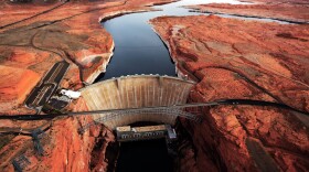 Photo of a dam stopping water between red rock cliffs