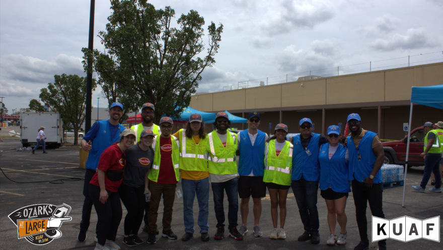 A group of volunteers smiles while serving Walmart and Tyson's Meals That Matter station on Walnut Avenue.