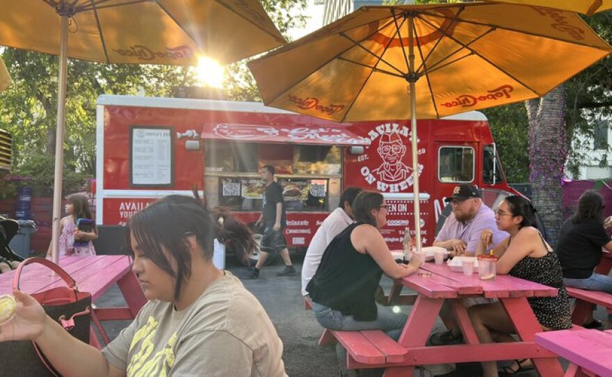 Customers enjoy their food outside of Davila's on Wheels at the Bésame food truck park in San Antonio.