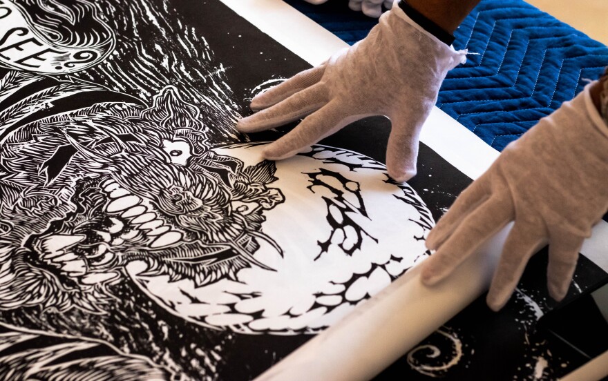 Curators unfurl artist Andy Ritzo's image titled "The Tyger," in preparation for the BIG INK exhibition. Thomas Iacobucci/WUSF Public Media