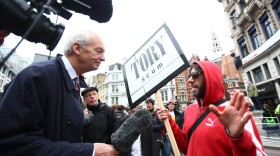 TV presenter Jon Snow speaks to a protester during the ceremonial funeral of former British Prime Minister Margaret Thatcher on April 17, 2013 in London. (Clive Rose/Getty Images)