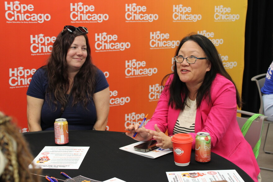 Illinois State Representative Sharon Chung sits a table, talking with scholars.