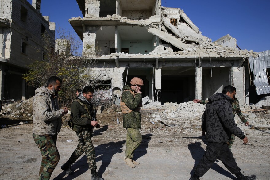 Russian and Syrian army soldiers gather at the last checkpoint before the front line with rebels, in Karam al-Tarab, east of Aleppo, Syria, Sunday, December 4.