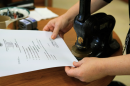 Riley Fujisaki, chief of staff for the lieutenant governor, embosses the state seal onto an apostille form.