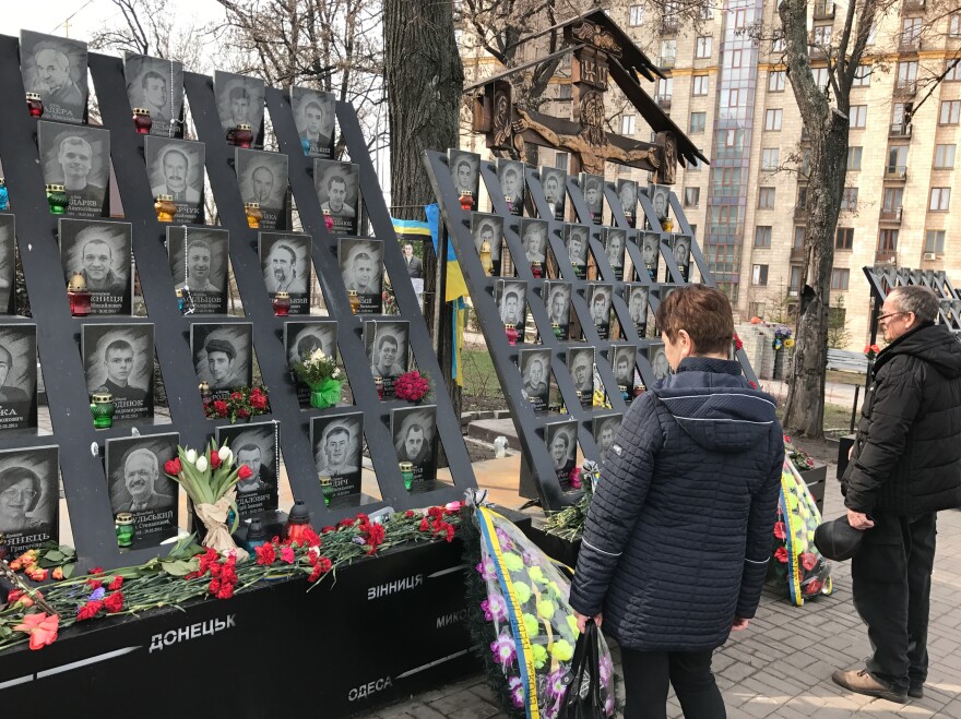 Passersby pay tribute to activists who were killed during 2014 anti-government protests near the Maidan, Kiev's main square.