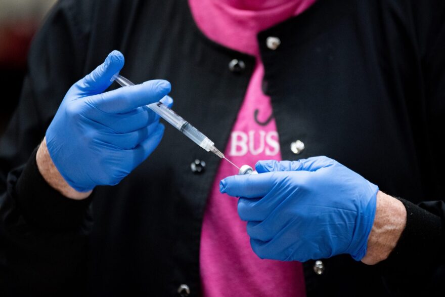 A healthcare worker fills a syringe with the COVID-19 Pfizer vaccine.