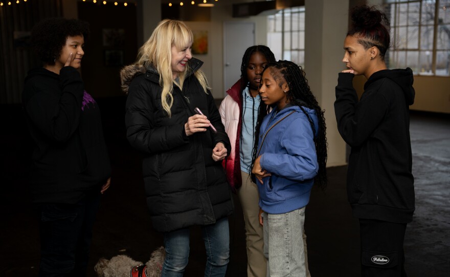 From left, Genesis, Holly Fulger, Aaliyah, Makhai and Bee discuss where their photos will go at the IlluminateHER exhibition.