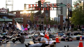 After protesting the presence of Westboro Baptist Church members outside Busch Stadium on Cardinals Pride Night, demonstrators lie in the street in honor of Kiwi Herring, a black trans woman who was killed by St. Louis police this week. Aug. 25, 2017