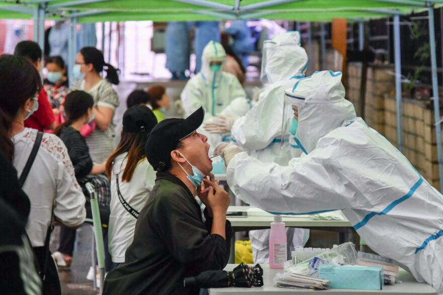 A medical worker takes a swab sample from a resident to be tested for the COVID-19 coronavirus in Wuhan in China's central Hubei province on May 14, 2020. - Nervous residents of China's pandemic epicentre of Wuhan queued up across the city to be tested for the coronavirus on May 14 after a new cluster of cases sparked a mass screening campaign. 