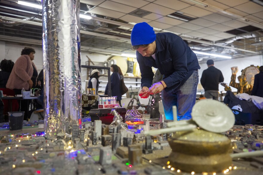 Joe Amato adjusts the lights on Space Farce 4242, which features an alien in a gigantic spaceship hovering over New Orleans.