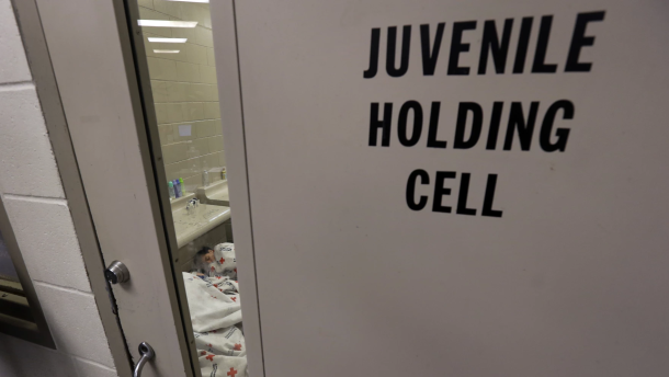 A door at a youth detention facility that reads Juvenile holding cell