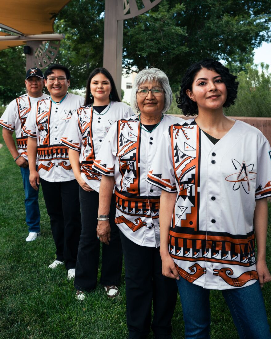Marvis Vallo, Collin Magdalena, Paris Wise, Patsy Him, and Brittney Juancho model the special jerseys, which draw inspiration from San Ildefonso, Cochiti, and other Pueblo traditional styles. The Albuquerque Isotopes will wear the jerseys and caps on Saturday, Aug. 8.