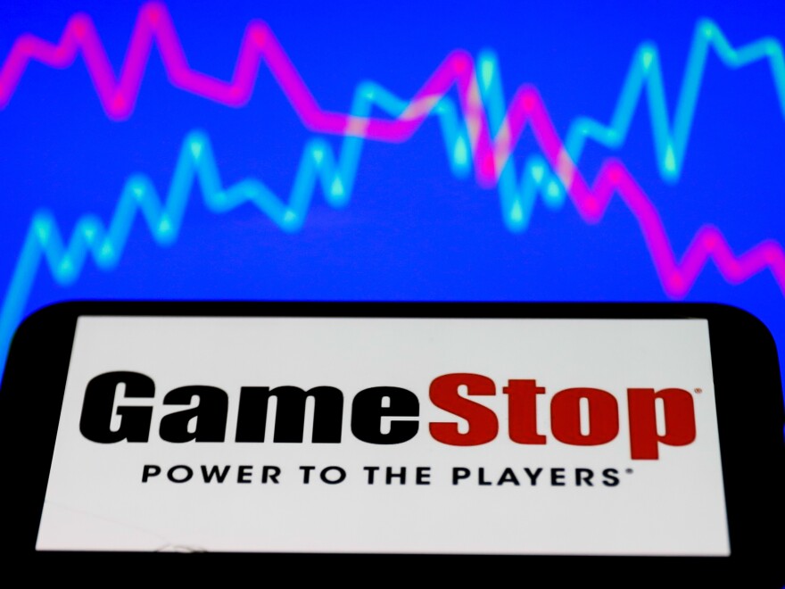 GameStop logo displayed on a phone screen and a illustrative stock chart on the background are seen in this illustration photo taken in Poland on January 28, 2021. In the last days the GameStop stock short squeeze continues. (Photo illustration by Jakub Porzycki/NurPhoto via Getty Images)