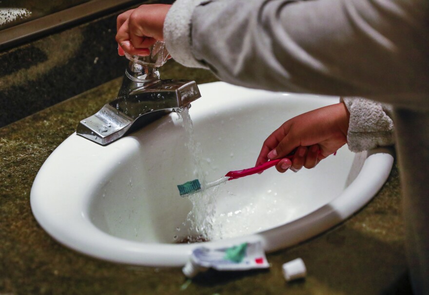 A child rinses a toothbrush in San Francisco on June 18, 2019. (Gabrielle Lurie/San Francisco Chronicle via AP, File)