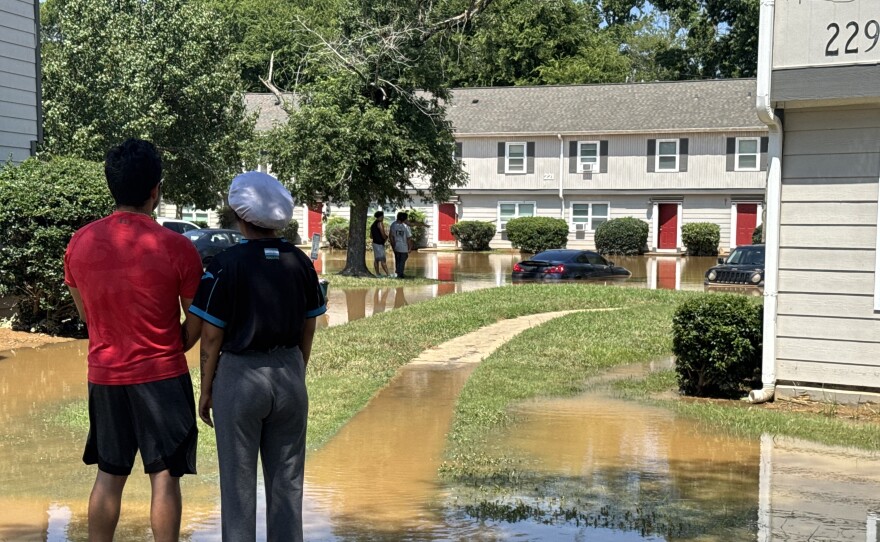 Residents assess the damage at Rippling Stream Townhomes in Durham after Tropical Storm Chantal came through the area on July 7, 2025. More than half a dozen units were flooded and several vehicles nearly submerged in the parking lot.