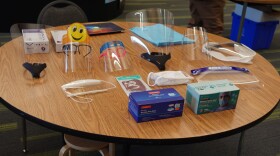 A variety of face masks and face shields displayed on a table at Huffman Elementary School.